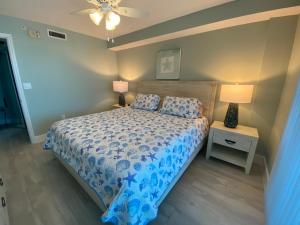 迈尔斯堡海滩Lover's Key Resort by Check-In Vacation Rentals的一间卧室配有一张带蓝色被子的床和两盏灯。