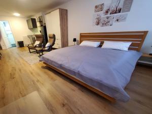 迈卡梅尔Ferienwohnung Blumenstiel的一间卧室配有一张大床和木制床头板