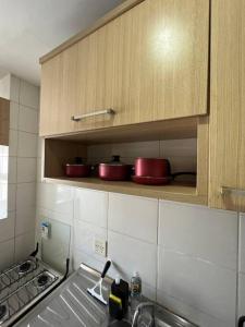 阿纳宁德瓦Belo Apartamento em Condomínio的架子上带红锅锅碗瓢盆的厨房