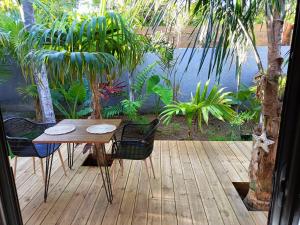 圣保罗Tiny house au lagon的一个带池塘的庭院里的一张木桌和椅子