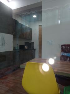加济阿巴德Namoh hotels的带厨房的客房内的黄椅