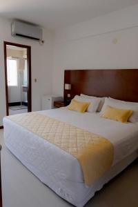 圣克鲁斯普林斯酒店的卧室配有一张带黄色枕头的大型白色床。