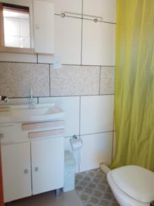 因贝Pousada do Osvaldo Imbé的浴室配有卫生间、盥洗盆和淋浴。