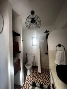 PoponguineLe Cabaoui的一间带卫生间和吊灯的小浴室