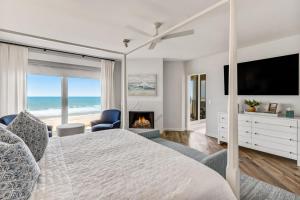 阿米莉亚岛Elegant Oceanfront Penthouse with Panoramic view, Omni Resort, Sea Dunes的一间卧室配有一张带壁炉和电视的床。