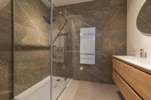 罗森达尔New Luxurious Apartment With 2 Bedrooms & Garden的带淋浴的浴室和玻璃门