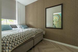 罗森达尔New Luxurious Apartment With 2 Bedrooms & Garden的卧室配有一张壁挂镜子的床