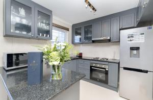 布鲁堡史特兰Ocean Tides 35的厨房配有灰色橱柜和花瓶,位于柜台上
