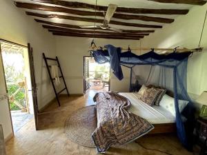 马特姆维Villa Maua Exclusive的一间卧室配有一张蓝色天蓬床
