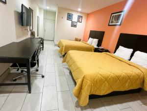 圣安东尼奥Pecan Valley Inn & Suites的酒店客房设有两张床和钢琴