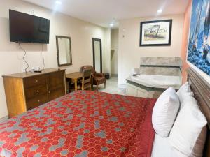 圣安东尼奥Pecan Valley Inn & Suites的一间卧室配有一张床,浴室设有浴缸