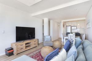 布鲁堡史特兰Portico 704的客厅配有蓝色的沙发和电视