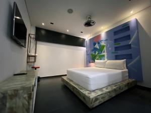 麦德林Hotel Medellin Art的卧室配有白色的床和电视