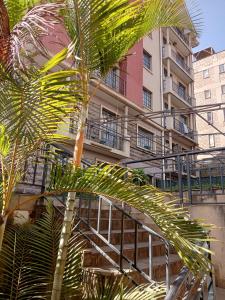 内罗毕Mvuli suites studio的一座建筑前的棕榈树