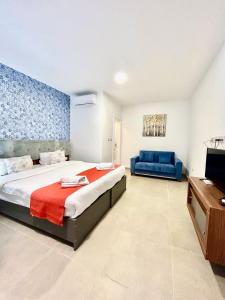 埃尔哥茨拉Marina Suites & apartments - Self catering - by Tritoni hotels的一间卧室配有一张大床和一张蓝色的沙发