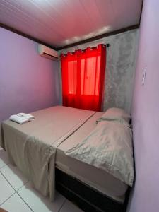费拉迪圣安娜Hoje Apartamentos的一间卧室配有一张红色窗户的床