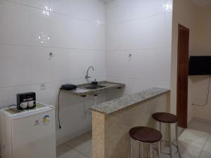 西波山Chalé Cipó Maia的一个带水槽和两个酒吧凳的小厨房