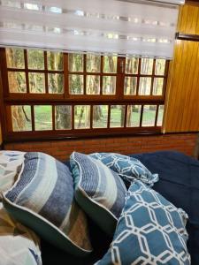 南卡希亚斯Chácara.lazer.cxs的客房设有带窗户的沙发上的枕头。