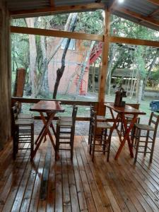 南卡希亚斯Chácara.lazer.cxs的木质门廊铺有木地板,配有桌椅