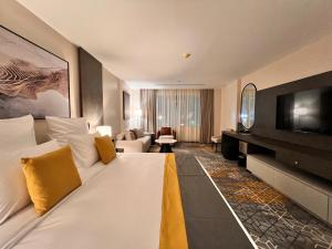 乌姆莱季Enala Hotel- Umluj的酒店客房设有一张大床和一台电视。