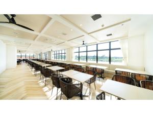 宫古岛Hotel Torifito Miyakojima Resort - Vacation STAY 79492v的一间设有桌椅和窗户的自助餐厅