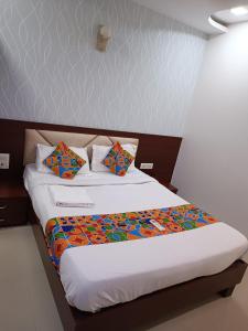 孟买Hotel Adore Residency的床上铺有色彩缤纷的床单和枕头