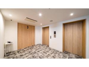 宫古岛Hotel Torifito Miyakojima Resort - Vacation STAY 79471v的一间空房间,设有两个木门和一张桌子