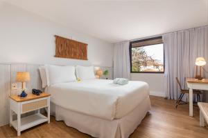 布希奥斯Hotel Aretê的卧室设有一张白色大床和一扇窗户。