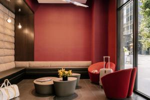 纽约Sonder at The Nash的餐厅设有红色的墙壁、红色的椅子和桌子