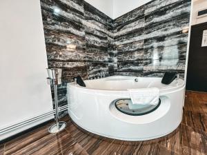 皮特什蒂Splendor Boutique Pitesti的浴室设有浴缸,拥有黑白砖墙