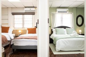 莱卡邦The Golden House @ Suvarnabhumi的一间卧室设有两张床和两个窗户。