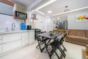 邦比尼亚斯Bombinhas Summer Beach的厨房以及带桌椅的起居室。