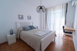 阿亚蒙特Apartamento Atardeceres的白色卧室,配有带毛巾的床