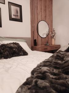 霍茨科波霍尔耶Luxury Wide View Apartment Pohorje Bellevue的卧室配有白色的床和镜子