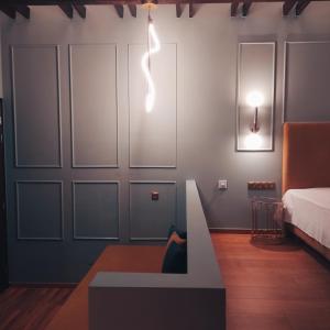 伊西翁L Suites The Writer's House的一间设有一张床的房间,墙上有灯
