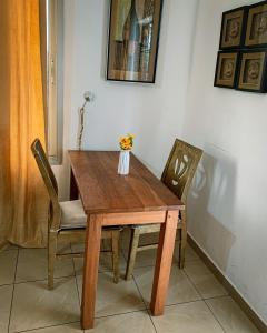 雅温得Charmant appartement proche de Yaoundé Centre的一张带两把椅子的木桌和花瓶