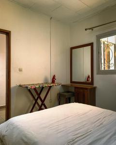 雅温得Charmant appartement proche de Yaoundé Centre的一间卧室配有一张床、一张书桌和一面镜子