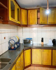 雅温得Charmant appartement proche de Yaoundé Centre的一间带木制橱柜和微波炉的厨房