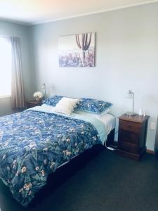陶朗加Clyde Suite的一间卧室配有一张带蓝色棉被的床