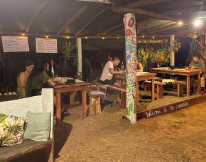 德雷克Rio Agujitas Eco Farm hostel and Tours的一群人坐在帐篷里的桌子上