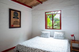 马尼萨莱斯Hacienda Venecia Hostel的白色的卧室设有床和窗户