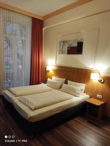 美因茨肯尼格索夫酒店的一间卧室配有一张大床和两个枕头