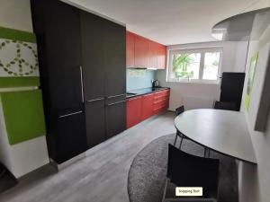 多恩比恩Komfortables Zimmer in ruhiger Wohnlage, inkl. Tax的厨房配有红色和绿色的橱柜和桌子