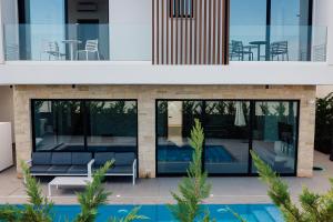 普罗塔拉斯Periyiali Konnos Villas Beach Resort的一座房子前面设有游泳池