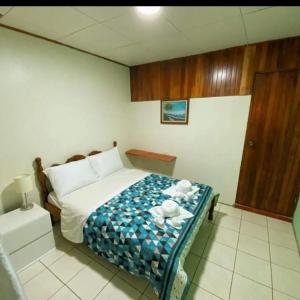 纽沃阿雷纳尔Cabinas Morpho Gardens的一间卧室配有一张带蓝白色毯子的床