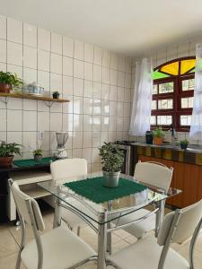 圣若泽Morada Verde - AP 2 quartos的厨房配有玻璃桌和白色椅子