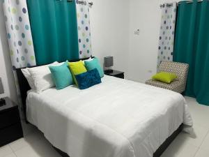 蒙特哥贝Meadows Place的卧室配有一张带彩色枕头的大型白色床。