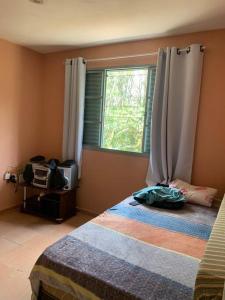 波苏阿莱格里Chácara Vale dos Eucaliptos的一间卧室设有一张床和一个窗口