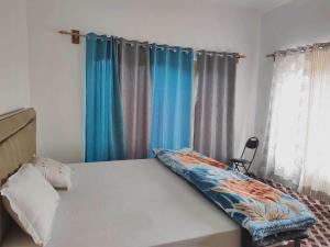 努布拉POP HOME 81129A Skayil Guest House的一间卧室配有蓝色窗帘的床