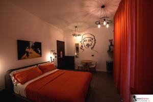 那不勒斯拖乐都站B＆B酒店的一间卧室配有一张带橙色毯子的床
